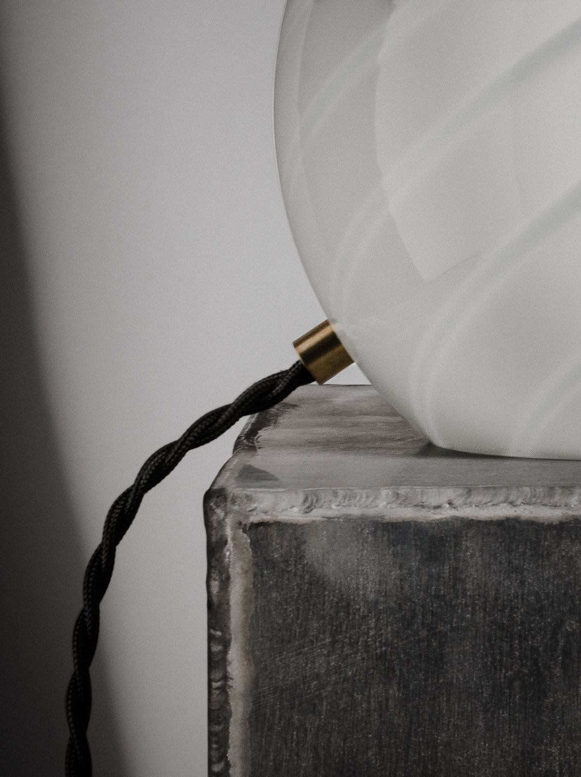 Sphere-shaped table lamp crafted from mouth-blown opaline glass. The design features a swirl pattern obtained using an original 1970s mould, specifically picked to give the lamp a clean expression. The piece includes hand-casted brass hardware.  Handmade in Murano, Italy Copenhagen Venice 